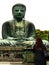 Kamakura, Kanagawa, KÅtoku-in / Japan: Back view of a woman dressed in black praying in front of the Great Buddha