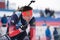 Kamchatka sportsman biathlete Aleksander Kapustin at finish after rifle shooting, skiing. Youth biathlon competitions