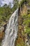 Kamyshlinsky waterfall in rocks of Altai mountains with rainbow