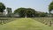 Kanchanaburi war cemetery with an abundance of rows of headstones and a grove of trees in the center