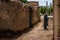 Kandovan, Iran - May 3, 2017: a city street with a clay fence and a woman completely sheltered