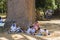 Kandy, Sri Lanka: 03/19/2019: Peradeniya Botanical Gardens school children and teacher seated under tree eating lunch