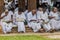 KANDY, SRI LANKA - JULY 19, 2016: White clothed Buddhist devotees eat at the grounds of the Temple of Sacred Tooth Relic