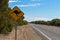 Kangaroo crossing road sign next to the road on Princess Highway