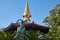 Kannon statue and the curved pagoda roof with golden sorin at Isshinji Temple. Tennoji. Osaka. Japan