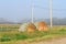 Kansas Alfalfa Bales by a fence with green grass and weeds in the fog.