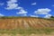 Kansas colorful hill with multicolored dirt and a fence with blue sky.