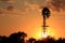 Kansas colorful orange and yellow sunset with clouds and a Windmill silhouette