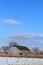 Kansas country Barn with a pasture, fence, snow, and blue sky that`s bright and colorful.