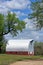 Kansas Country Red Barn with tree`s and blue sky with white clouds out in the country.