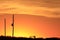 Kansas golden orange and yellow sky with power line silhouettes out in the country.