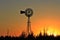 Kansas Orange colorful Sunset with a Windmill ,tree, and Power Lines Silhouettes out in the country.