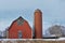 Kansas Red Barn with Snow out in the country that`s bright and colorful with blue Sky.