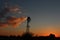 Kansas Windmill Sunset with bright and colorful clouds out in the country.