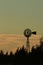 Kansas Windmill sunset with a tree silhouette with a colorful green sky