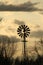 Kansas Windmill sunset with a tree silhouette with a colorful sky