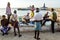 Kanyakumari, Tamil Nadu, India. 08/14/14. A man selling fish on the edge of the beach as people look on, with the statue of Viveka