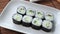 Kappa Maki classic roll with cucumber. Hosomaki thin rolls, simple rolls, small rolls, with cucumber. top view on a white plate.