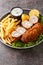 Karageorge Schnitzel Serbian Stuffed Cutlet served with french fries and tartar sauce close-up in a plate. Vertical