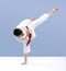 Karate athlete hits a kick on a light background