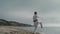 Karate athlete practicing kicks on sunny beach. Sporty man training martial arts