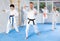 Karate instructor demonstrating kata sequence of movements to group of teenagers