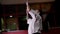 Karate master in kimono does exercises with bar-bell in gym