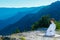 Karate master meditating on top of a mountain wearing kimono while looking down at the mountain lake