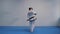 Karate and taekwondo woman in white kimono with black belt trains punches and kicks in blue sports gloves. Female