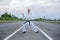A karate trainer is standing in a protective pose on the road for cars.
