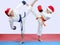 In karategi and cap of Santa Claus sportsmens are beating kicks