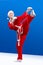 Karateka in the suit of Santa Claus hits a kick leg