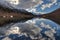 Kardyvach mountain lake with sky reflections. Scenic dramatic autumn sunset landscape. Sochi, Russia, Caucasus mountains