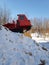 Karelian red tractor is behind a snowy mountain