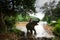 A Karen man bathing with asian elephant on a riverbank