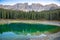 Karersee or Lago di Carezza, is a lake with mountain range of the Latemar group on background in the Dolomites in Tyrol