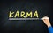 Karma Word Hand Writing On Chalkboard. Human hand Underlining a line below karma Term. Black Chalk board Concept