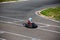 Kart racer rides a kart from a turn to the finish line in a competition