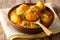 Kashmiri dum aloo: spicy potato with sauce closeup on the plate.