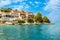 Kassiopi town on Corfu island, Greece. Picturesque fishing village on rugged seashore with colorful houses, luxury