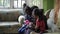 Kathmandu, Nepal - 27 November 2019: Nepali Indian children talk sitting on the couch in the room and examining the