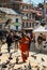 Kathmandu, Nepal - October 2019: A saffron-robed Buddhist monk with a begging bowl recites mantras.