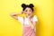 Kawaii asian girl showing v-sign and pouting cute, making silly face with makeup, standing on yellow background