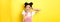 Kawaii asian girl showing v-sign and pouting cute, making silly face with makeup, standing on yellow background