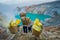 KAWEH IJEN, INDONESIA: Local miners carrying heavy baskets of yellow sulfur rocks up mountain side, tourist hiking