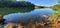 kayak on calm lake water on clear sunny day on summer blue skies docked near rock outcropping