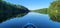 kayak on calm lake water on clear sunny day on summer blue skies docked near rock outcropping