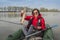 Kayak fishing. Fisher girl holding pike fish trophy on inflatable boat with fishing tackle at lake