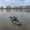 Kayak fishing. Fisherman caught pike fish on inflatable boat with fishing tackle at lake