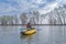 Kayak fishing at lake. Fisherwoman on inflatable boat with fishing tackle